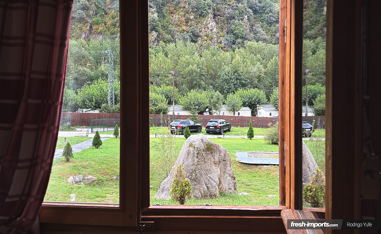 Vistas desde la ventana de un bungalow del Camping Frontera Park con los Porsche Cayenne al fondo